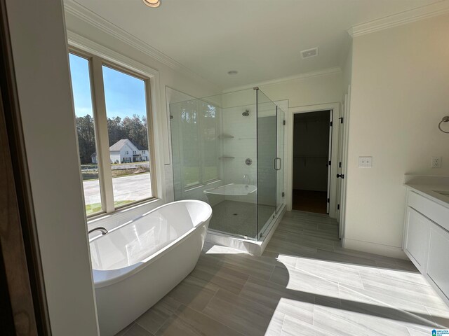 bathroom featuring shower with separate bathtub, ornamental molding, and vanity