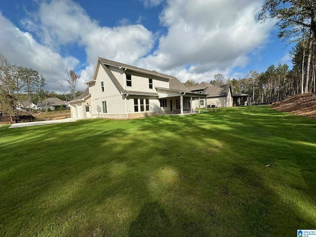 back of house with a garage and a lawn