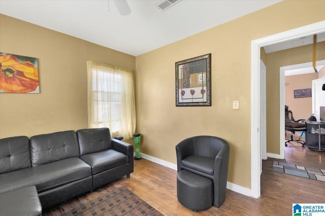 living room with dark wood-type flooring and ceiling fan