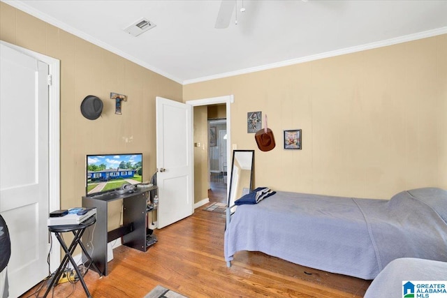 bedroom featuring ceiling fan, crown molding, and hardwood / wood-style flooring