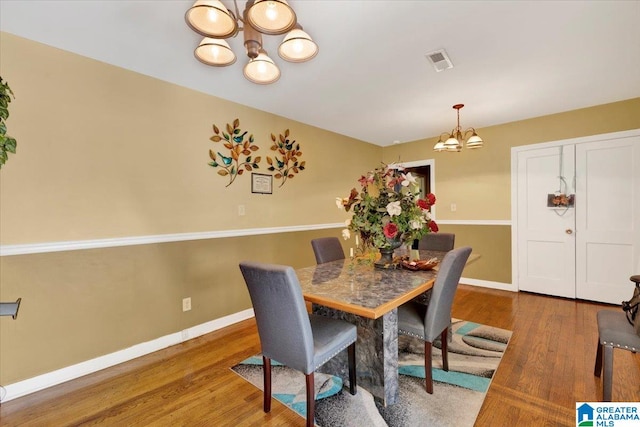 dining space with an inviting chandelier and wood-type flooring