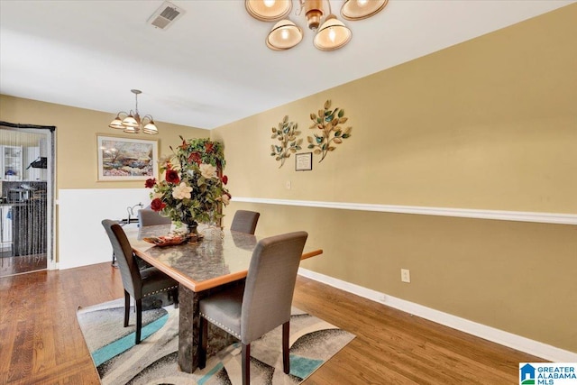 dining room with a notable chandelier and hardwood / wood-style flooring