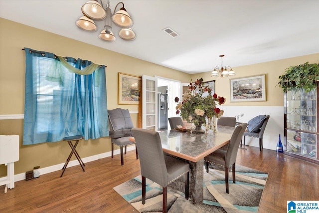 dining room featuring an inviting chandelier and dark wood-type flooring