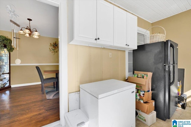 laundry room with hardwood / wood-style floors and a chandelier