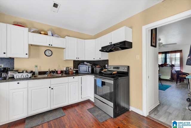 kitchen featuring dark wood-type flooring, stainless steel appliances, sink, tasteful backsplash, and ceiling fan