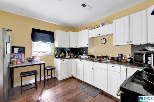 kitchen with white cabinetry, sink, tasteful backsplash, and dark hardwood / wood-style floors