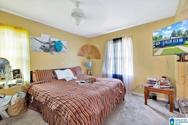 bedroom with ceiling fan, multiple windows, and carpet flooring