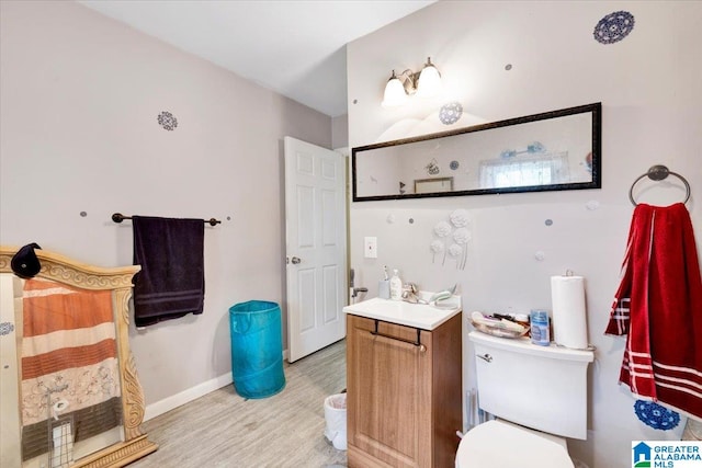 bathroom featuring wood-type flooring, vanity, and toilet