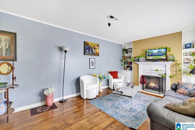 living room with hardwood / wood-style flooring and crown molding