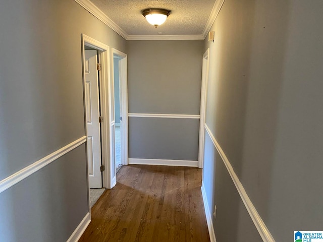 hall featuring ornamental molding, dark hardwood / wood-style floors, and a textured ceiling