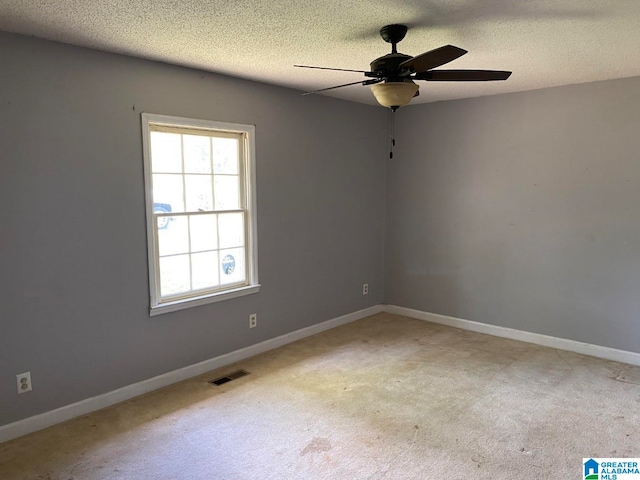 carpeted empty room with plenty of natural light, ceiling fan, and a textured ceiling