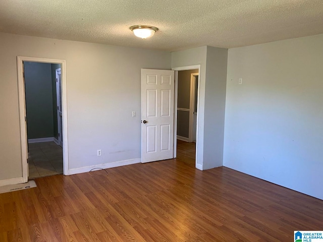 spare room featuring hardwood / wood-style floors and a textured ceiling