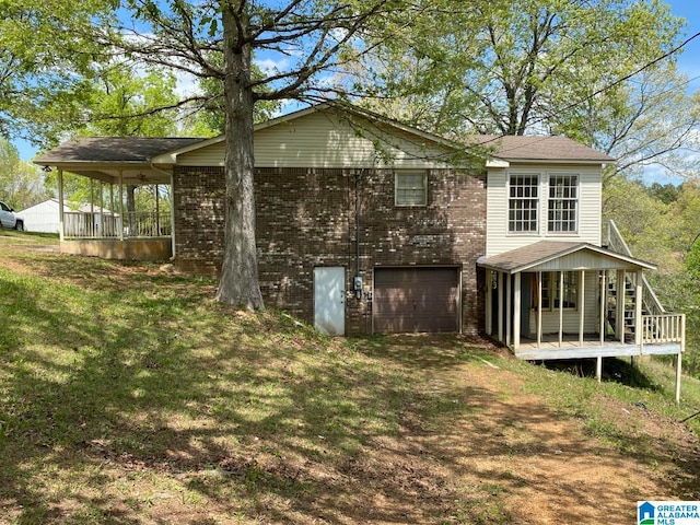 back of property featuring a garage and a yard