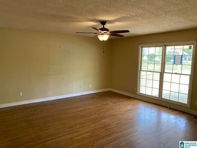 unfurnished room with ceiling fan, dark hardwood / wood-style flooring, and a textured ceiling