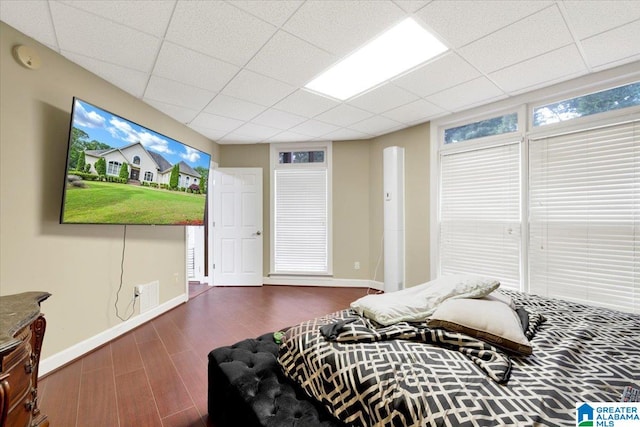 bedroom featuring hardwood / wood-style flooring and a drop ceiling