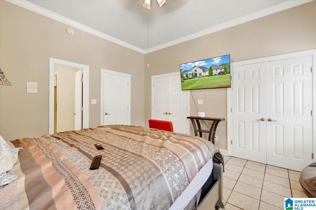 bedroom featuring two closets, crown molding, ceiling fan, and light tile patterned floors