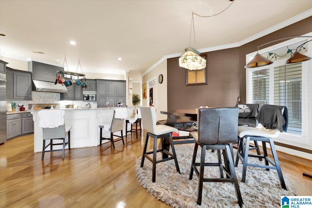 dining area with crown molding and light wood-type flooring