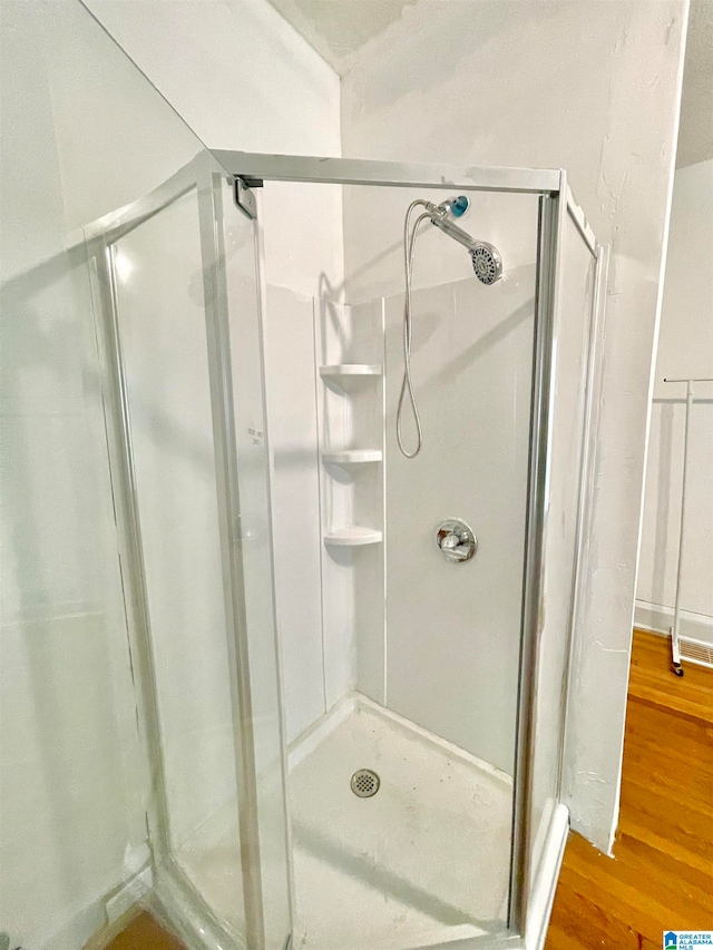 bathroom featuring hardwood / wood-style floors and walk in shower