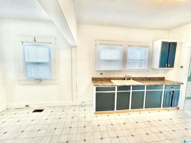 kitchen with sink, a wealth of natural light, and blue cabinets