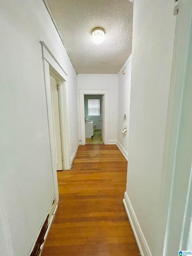 hall featuring a textured ceiling and wood-type flooring