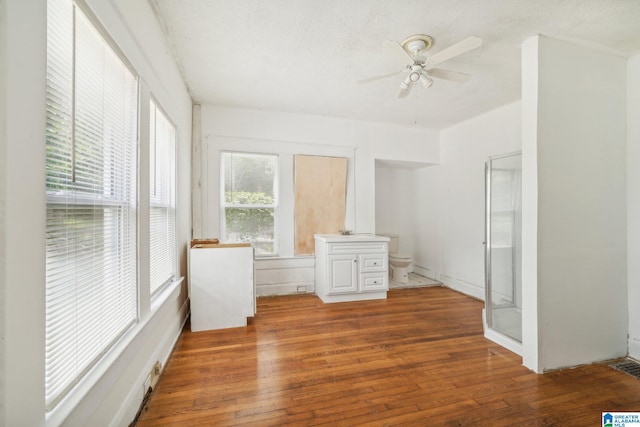 interior space featuring ceiling fan, hardwood / wood-style floors, and a textured ceiling