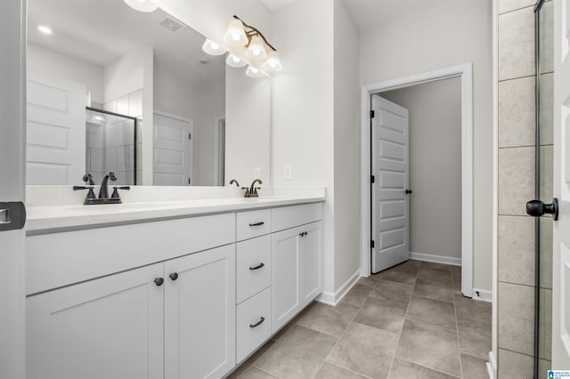 bathroom with a shower with shower door, tile patterned floors, and vanity