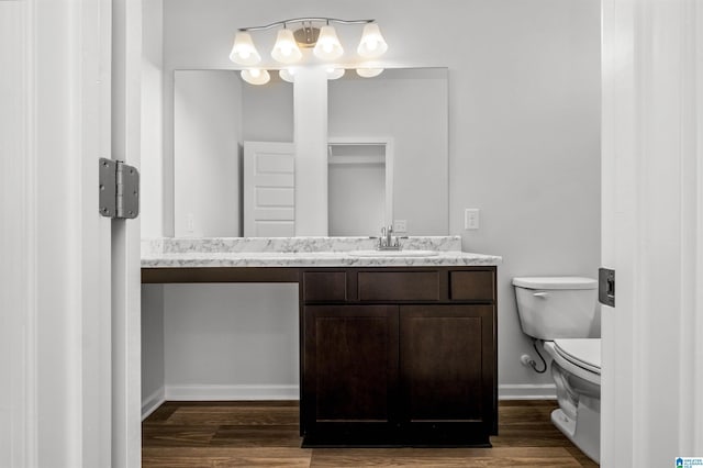 bathroom featuring toilet, vanity, and hardwood / wood-style floors