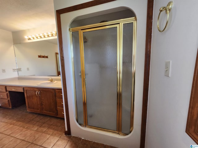 bathroom featuring a shower with shower door, tile flooring, and vanity