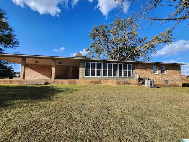 back of house with a yard and central AC unit