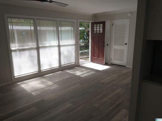 foyer with ornamental molding, dark wood-type flooring, and ceiling fan