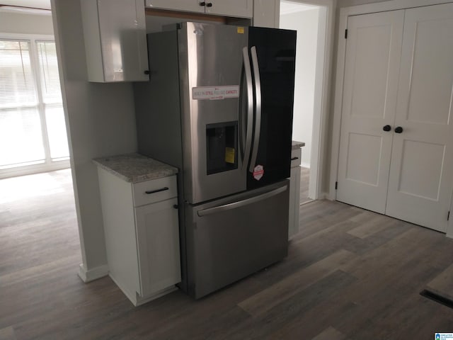 kitchen with white cabinets, dark wood-type flooring, and stainless steel refrigerator with ice dispenser