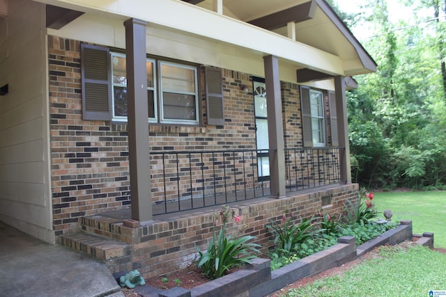 entrance to property with a porch and a lawn