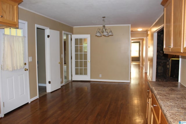 spare room with an inviting chandelier and dark hardwood / wood-style flooring