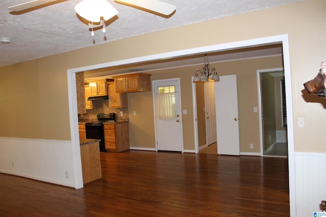 kitchen featuring black range with electric stovetop, backsplash, dark wood-type flooring, and ceiling fan with notable chandelier