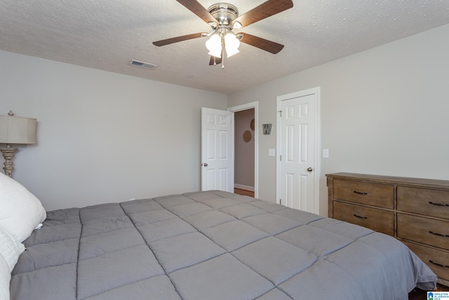 bedroom with ceiling fan and a textured ceiling