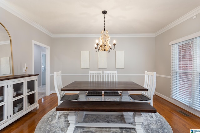 dining space featuring dark hardwood / wood-style flooring, a chandelier, and ornamental molding