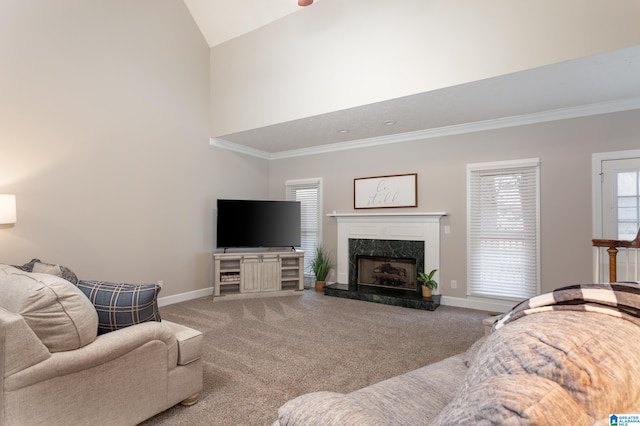 carpeted living room with high vaulted ceiling, ornamental molding, and a high end fireplace