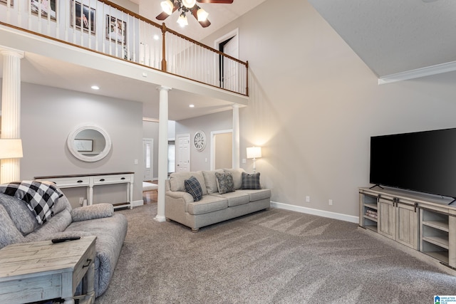 living room featuring carpet, ceiling fan, a towering ceiling, and ornate columns