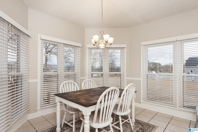 tiled dining room with a textured ceiling and a notable chandelier