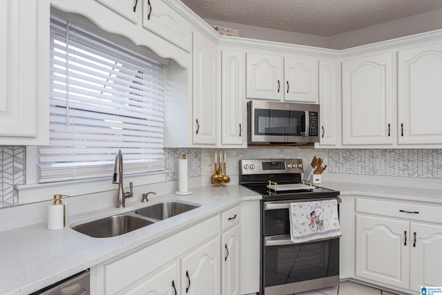 kitchen featuring white cabinets, a textured ceiling, stainless steel appliances, and sink