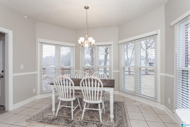 tiled dining space featuring a textured ceiling, an inviting chandelier, and plenty of natural light