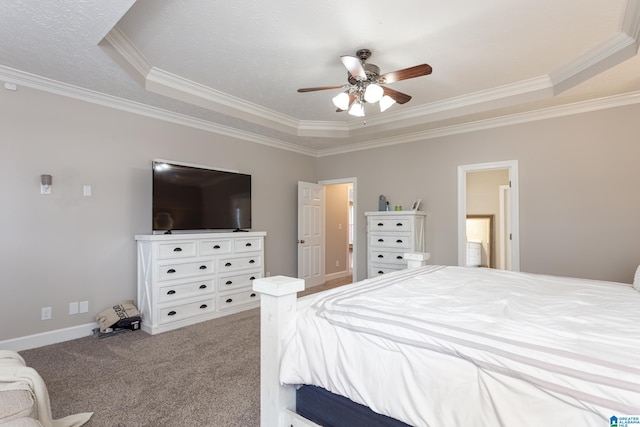 carpeted bedroom with ceiling fan, a raised ceiling, and ornamental molding