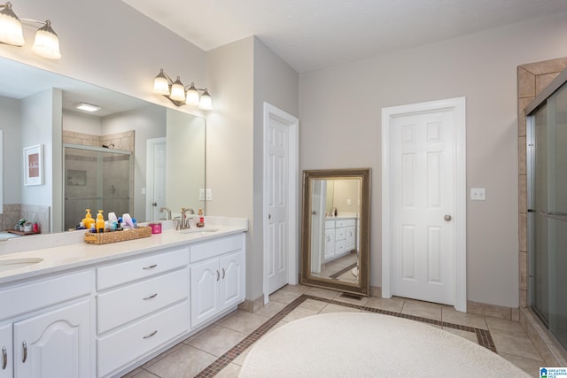 bathroom with tile patterned flooring, vanity, and walk in shower