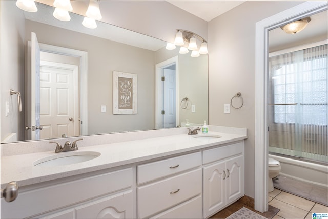 full bathroom with shower / bath combination with glass door, vanity, tile patterned floors, and toilet