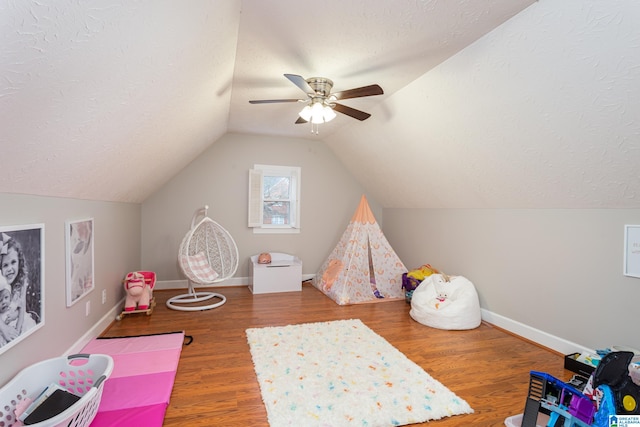 rec room featuring hardwood / wood-style floors, a textured ceiling, vaulted ceiling, and ceiling fan