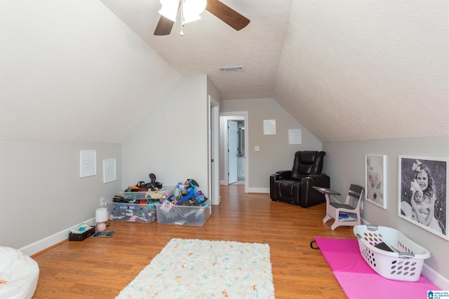 additional living space with a textured ceiling, ceiling fan, lofted ceiling, and hardwood / wood-style flooring