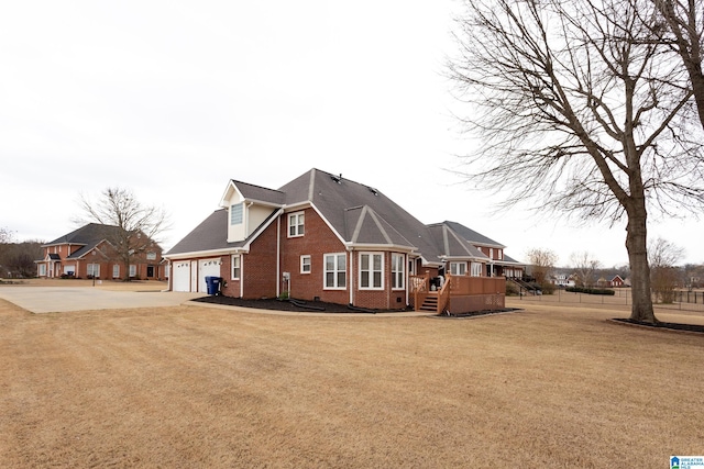 view of side of home featuring a deck, a garage, and a lawn