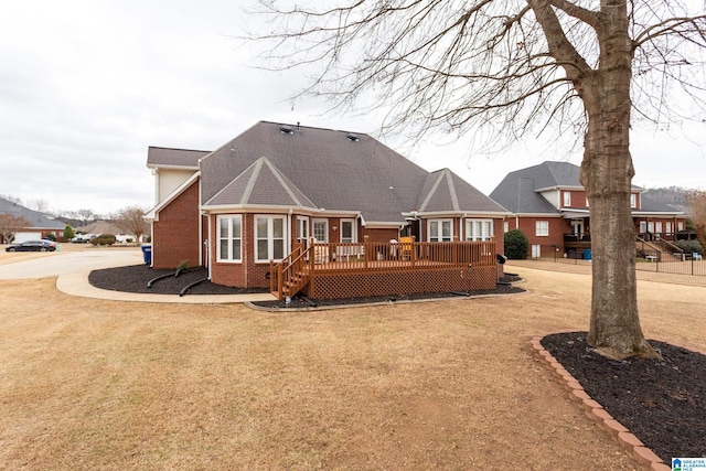 back of property featuring a deck and a lawn