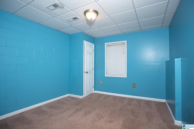 carpeted spare room with a drop ceiling