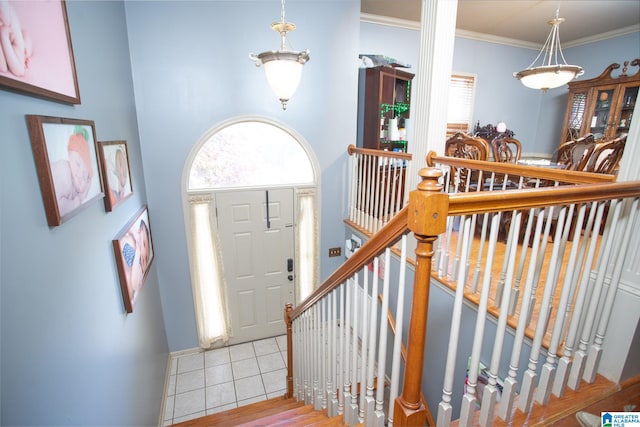 entrance foyer with crown molding and light tile floors